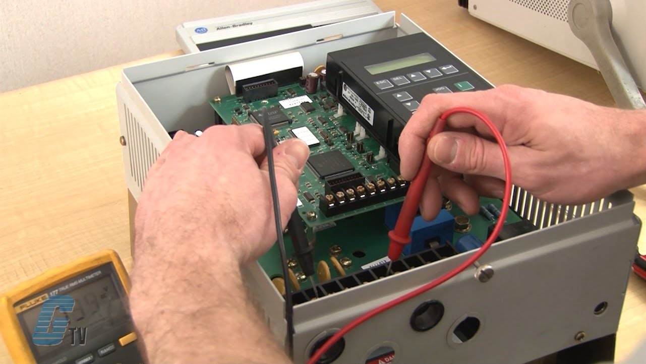 Technician testing electrical equipment with multimeter and test leads